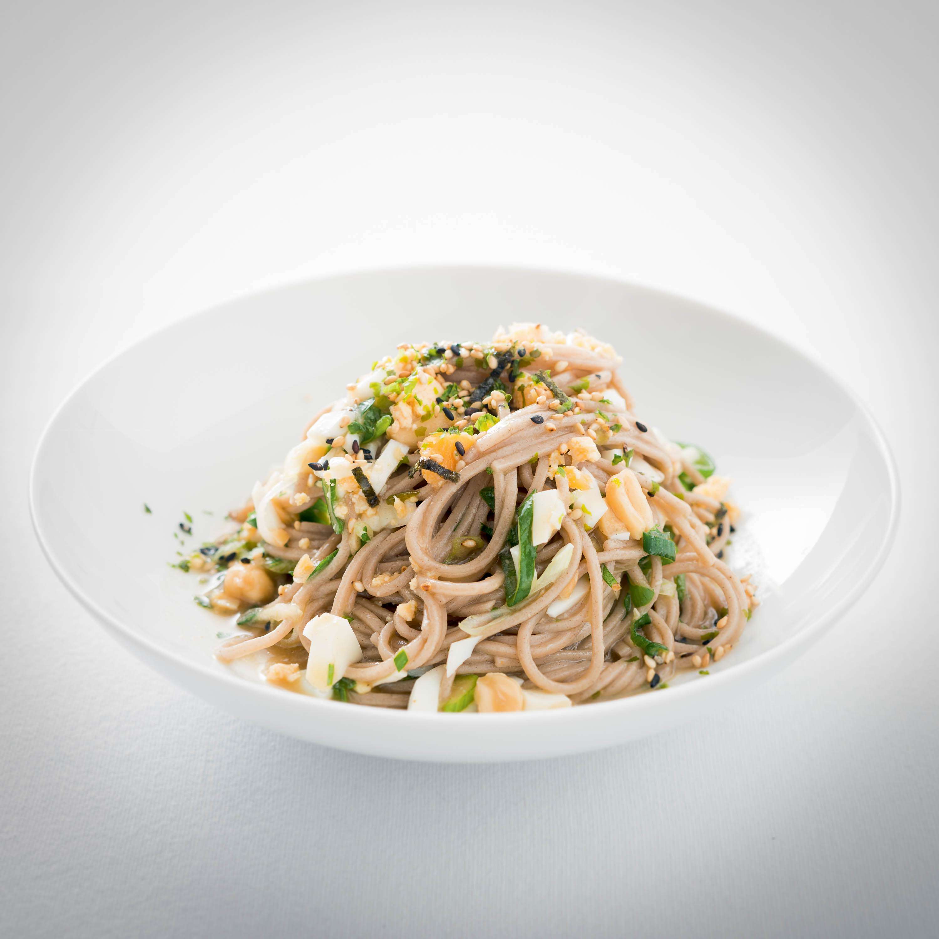 Udon-Nudelsalat mit Eiern, Miso-Vinaigrette, Frühlingszwiebeln, gehackten Erdnüssen und Koriander