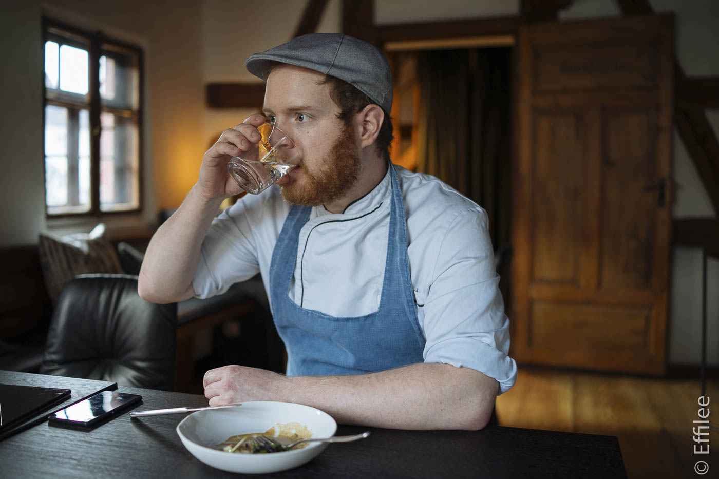 Ein Teller mit Felix Schneider vom Sosein: Stör, schwarze Zwiebel, gebundener Dashi, Grünkohl, Rauchöl