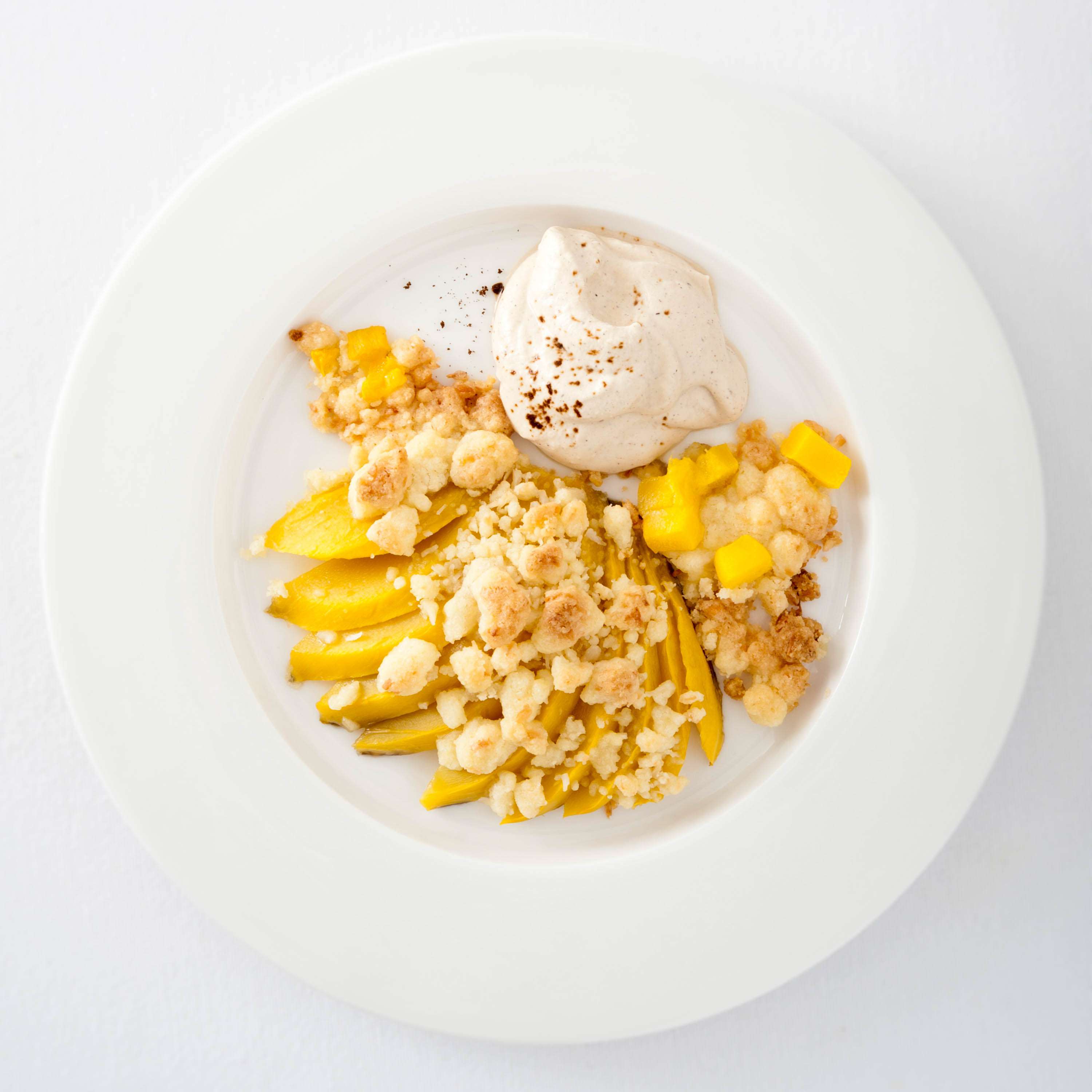 Mango mit Kokosstreuseln aus dem Ofen mit Espresso-Sahne